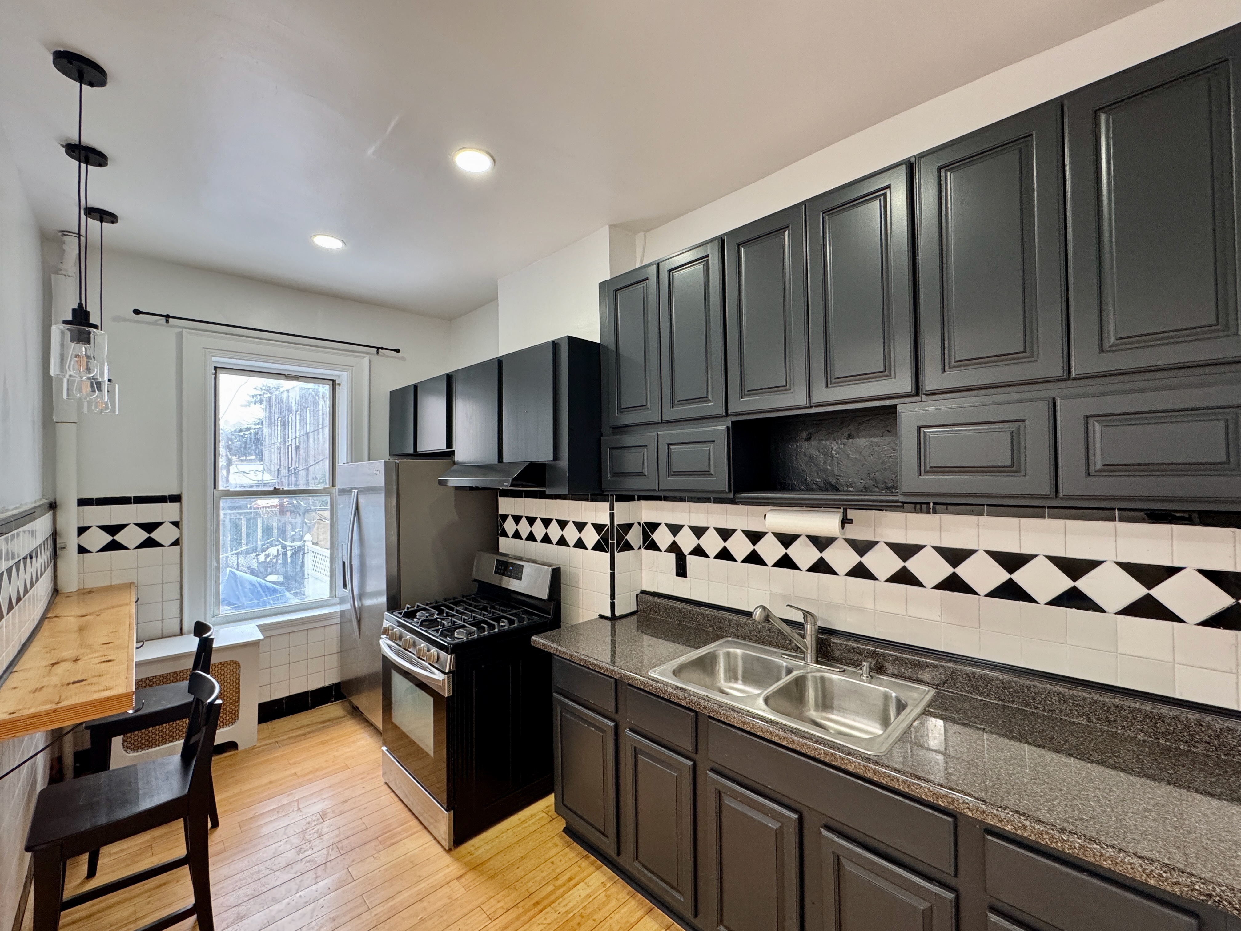 a kitchen with stainless steel appliances granite countertop a stove a sink and a refrigerator