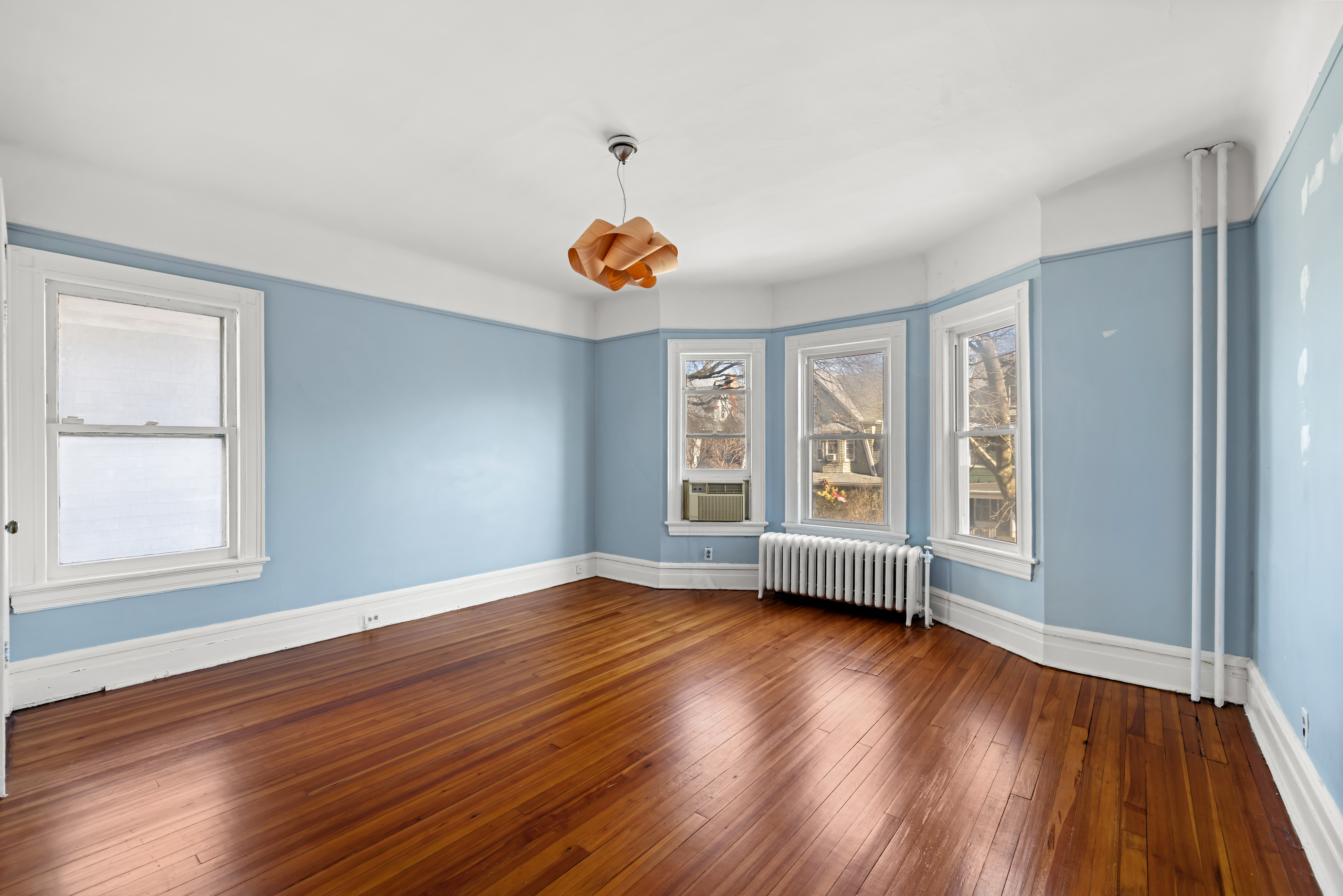 792 East 21st Street Brooklyn, NY 11210 - Photo 13 of 29 an empty room with wooden floor and windows
