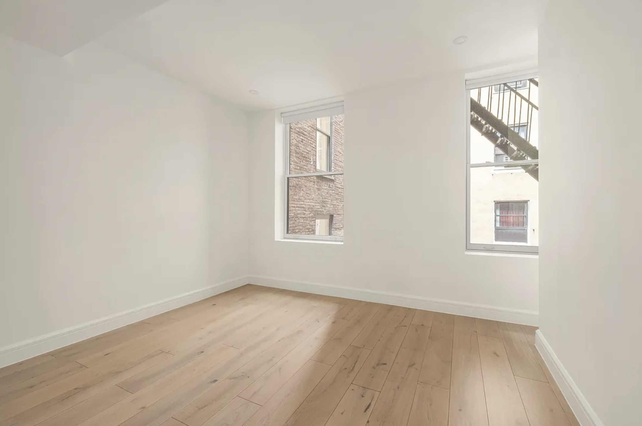 17 West 24th Street, Unit 4 Manhattan, NY 10010 - Photo 5 of 8 an empty room with wooden floor and windows