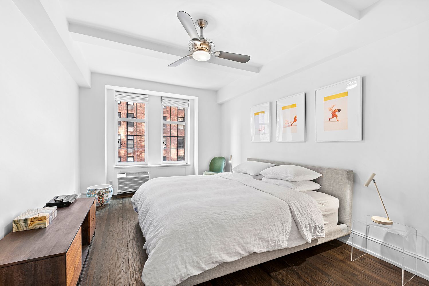 410 West 24th Street, Unit 6J Manhattan, NY 10011 - Photo 4 of 8 a large bed sitting in a bedroom next to a window