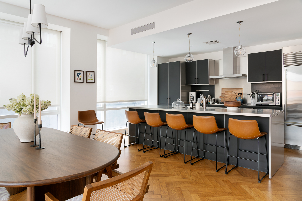 330 Spring Street, Unit 5A Manhattan, NY 10013 - Photo 5 of 13 a kitchen with stainless steel appliances kitchen island granite countertop a table chairs and sink