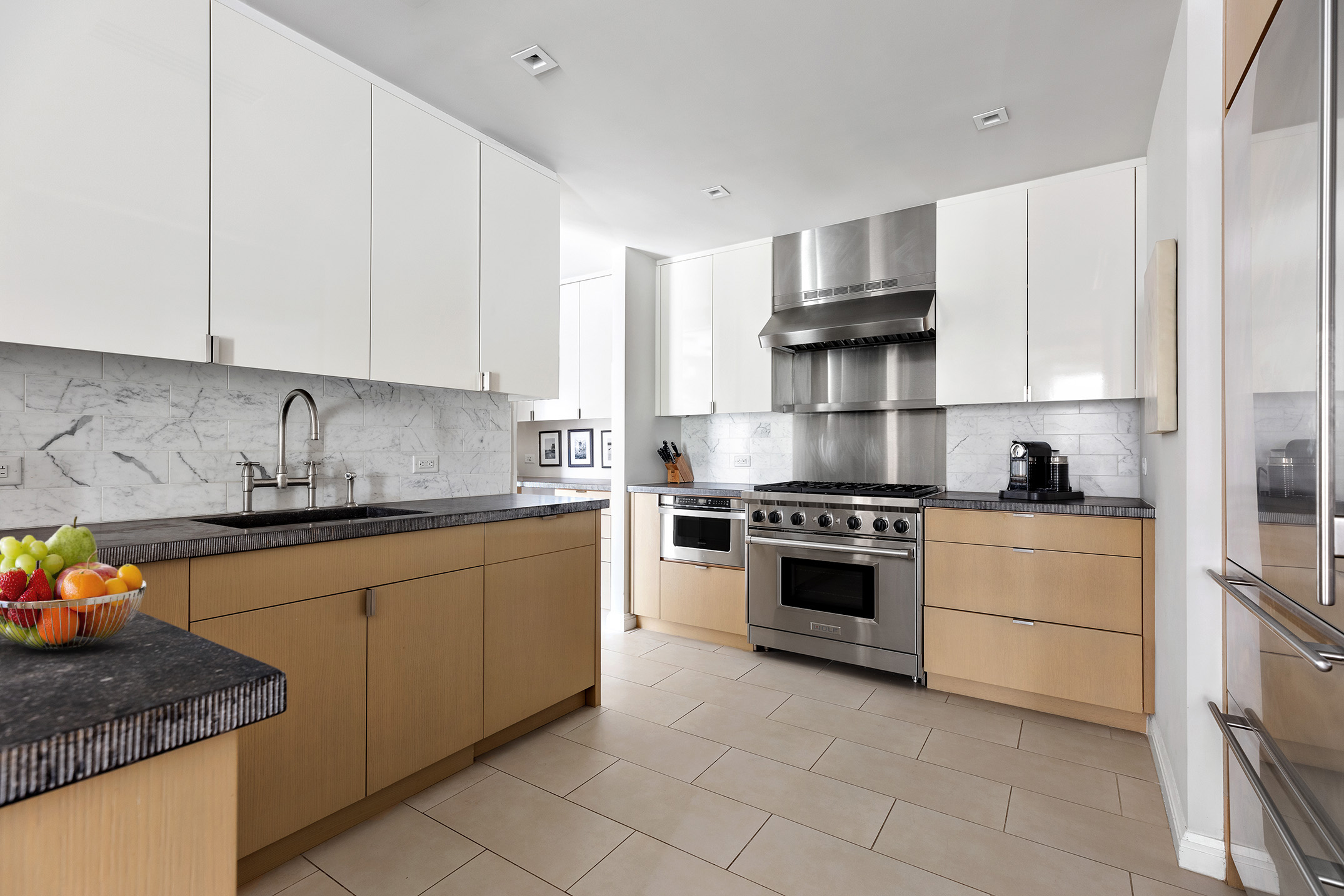 141 East 88th Street, Unit 7A Manhattan, NY 10128 - Photo 6 of 15 a kitchen with stainless steel appliances granite countertop a stove sink and cabinets