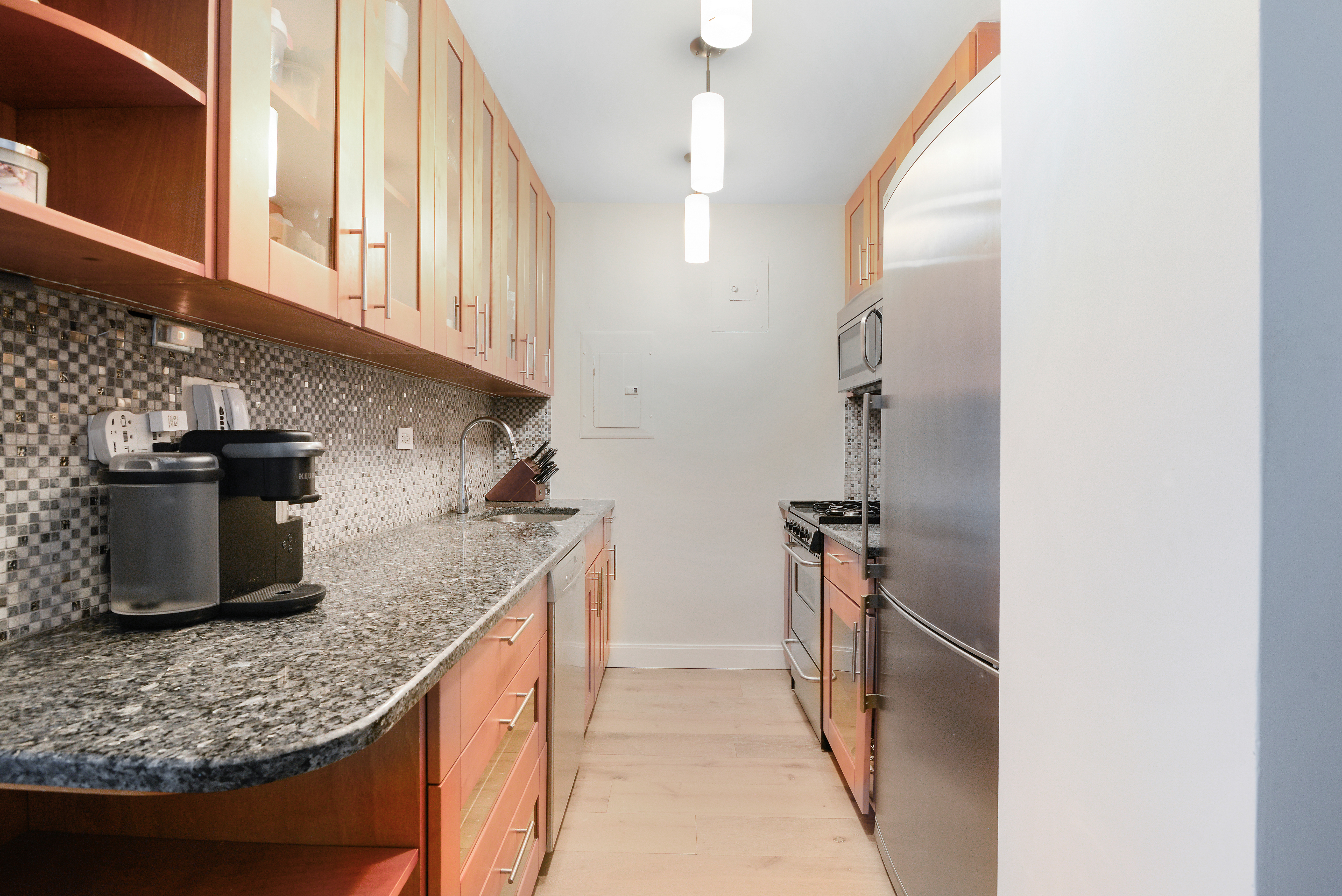 201 East 21st Street, Unit 7G Manhattan, NY 10010 - Photo 6 of 11 a kitchen with stainless steel appliances granite countertop a sink stove and refrigerator