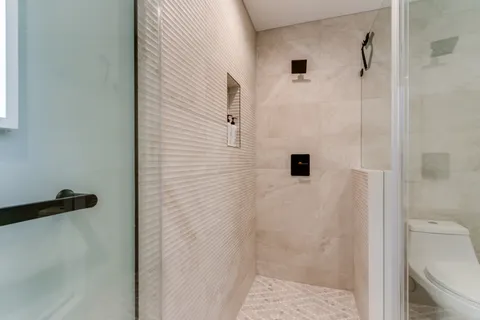 a bathroom with a shower and a glass door