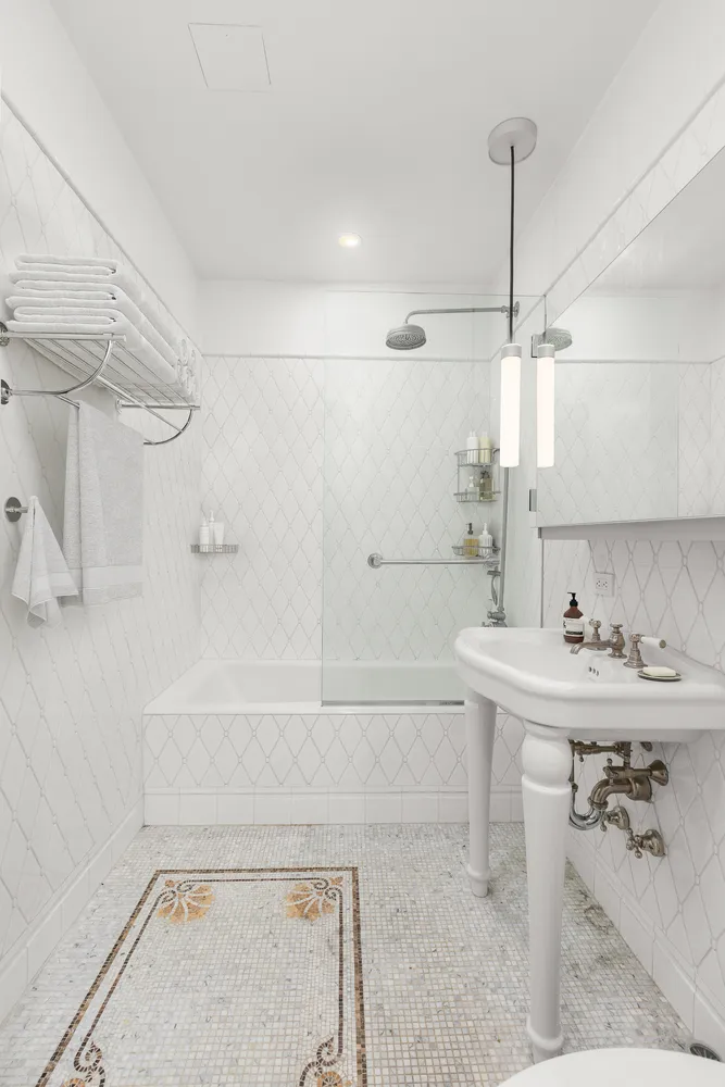 a bathroom with a sink a toilet a mirror and bathtub