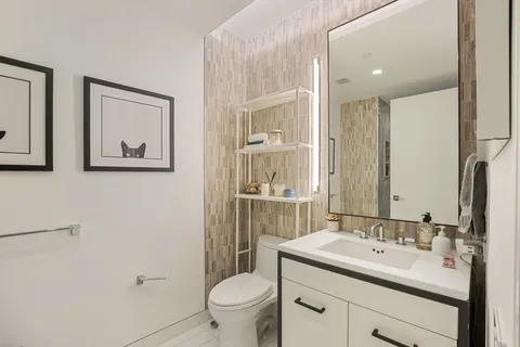 a bathroom with a toilet sink and mirror
