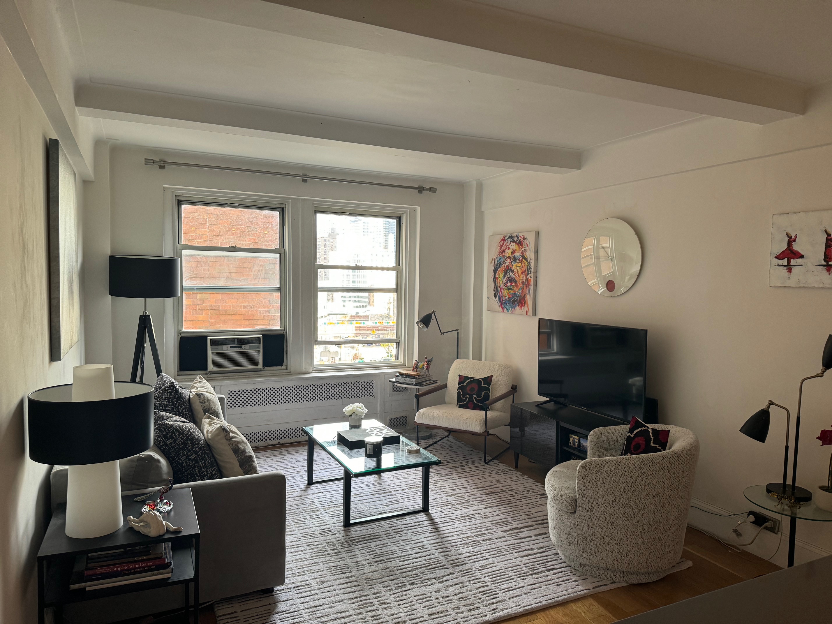 433 West 34th Street, Unit 6K Manhattan, NY 10001 - Photo 4 of 12 a living room with furniture a flat screen tv and a window