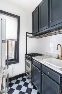 a kitchen with a stove a sink and a window