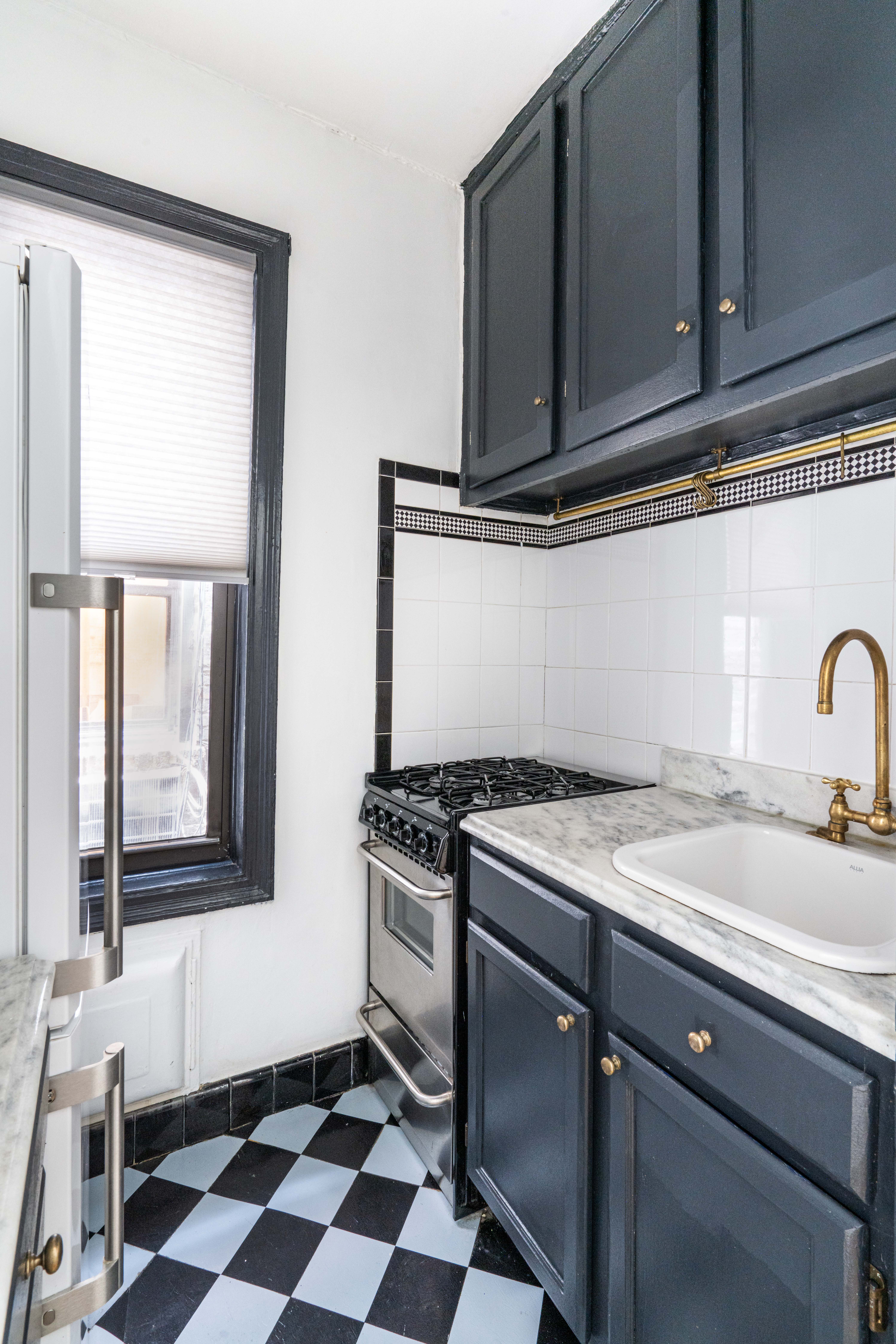 121 East 88th Street, Unit 3A Manhattan, NY 10128 - Photo 3 of 7 a kitchen with a stove a sink and a window