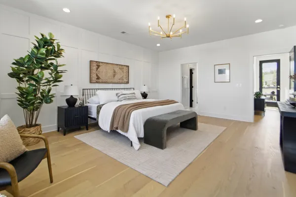 a spacious bedroom with a bed and a chandelier
