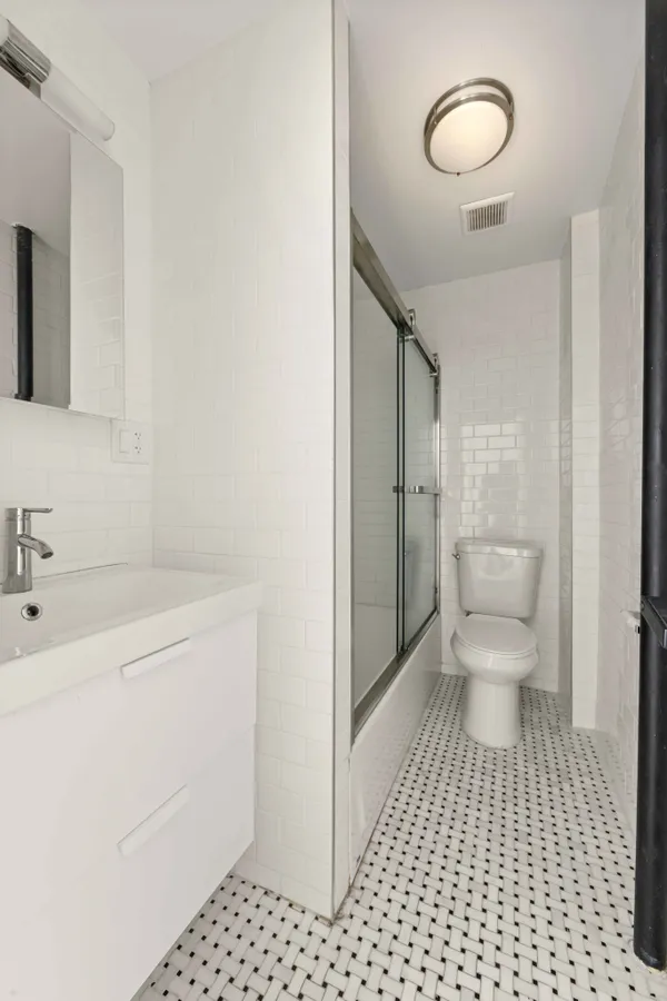 a bathroom with a sink a toilet and a mirror