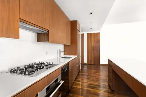 a kitchen with a sink and wooden floor