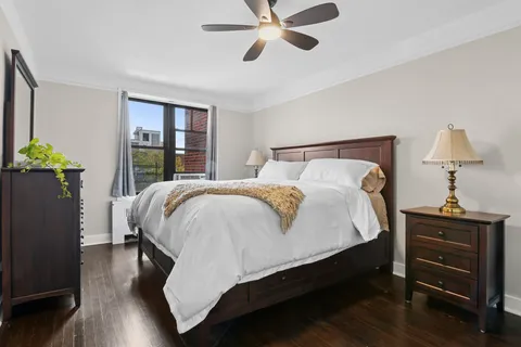 a bed sitting in a bedroom next to a window with pc on the table