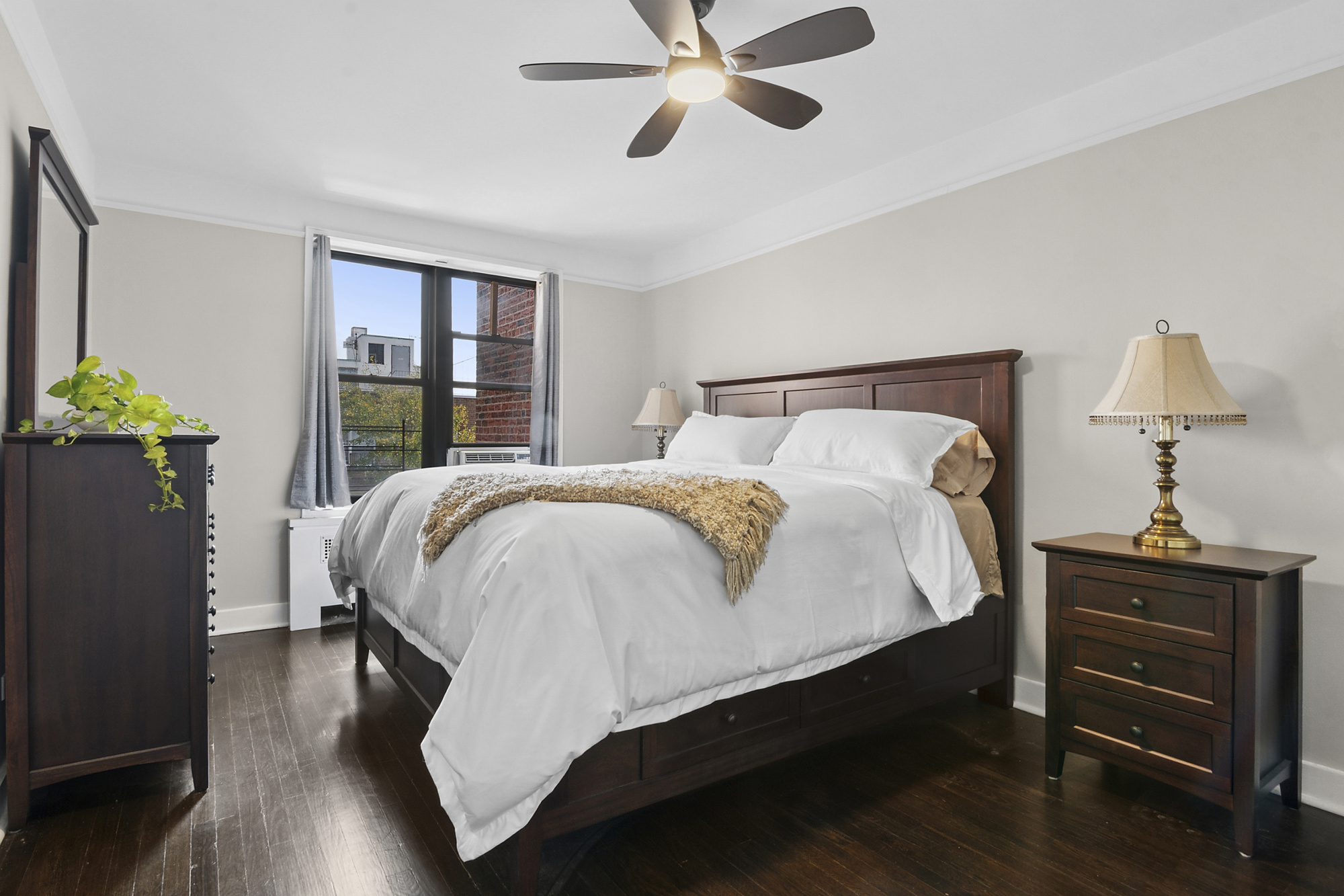 9511 Shore Road, Unit 606 Brooklyn, NY 11209 - Photo 5 of 17 a bed sitting in a bedroom next to a window with pc on the table