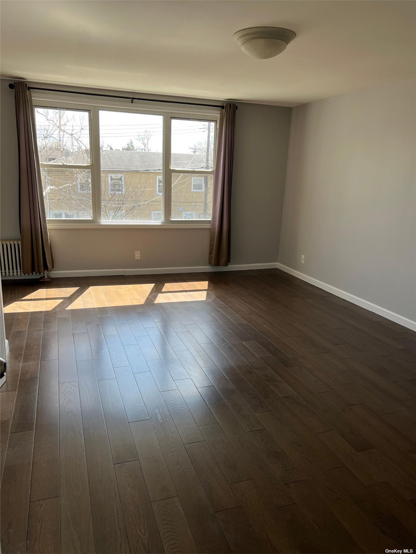 204-11 46th Avenue Queens, NY 11361 - Photo 5 of 7 an empty room with wooden floor and windows