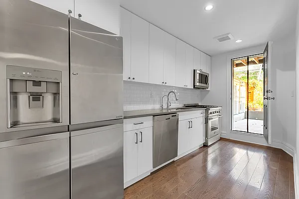 752 Jefferson Avenue, Unit GARDEN Brooklyn, NY 11221 - Photo 3 of 8 a kitchen with stainless steel appliances granite countertop a refrigerator a sink and white cabinets
