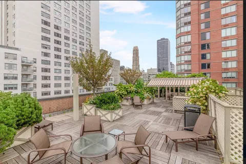 a view of a patio with plants and chairs and tables