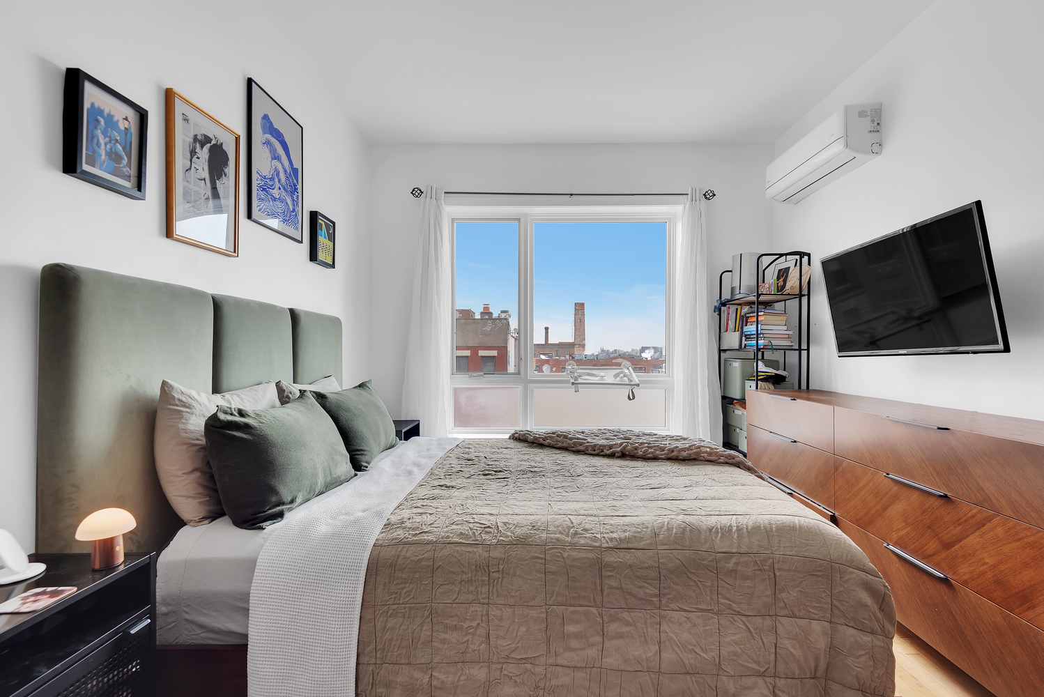 228 Bushwick Avenue, Unit 6A Brooklyn, NY 11206 - Photo 5 of 8 a bedroom with a bed and a flat screen tv