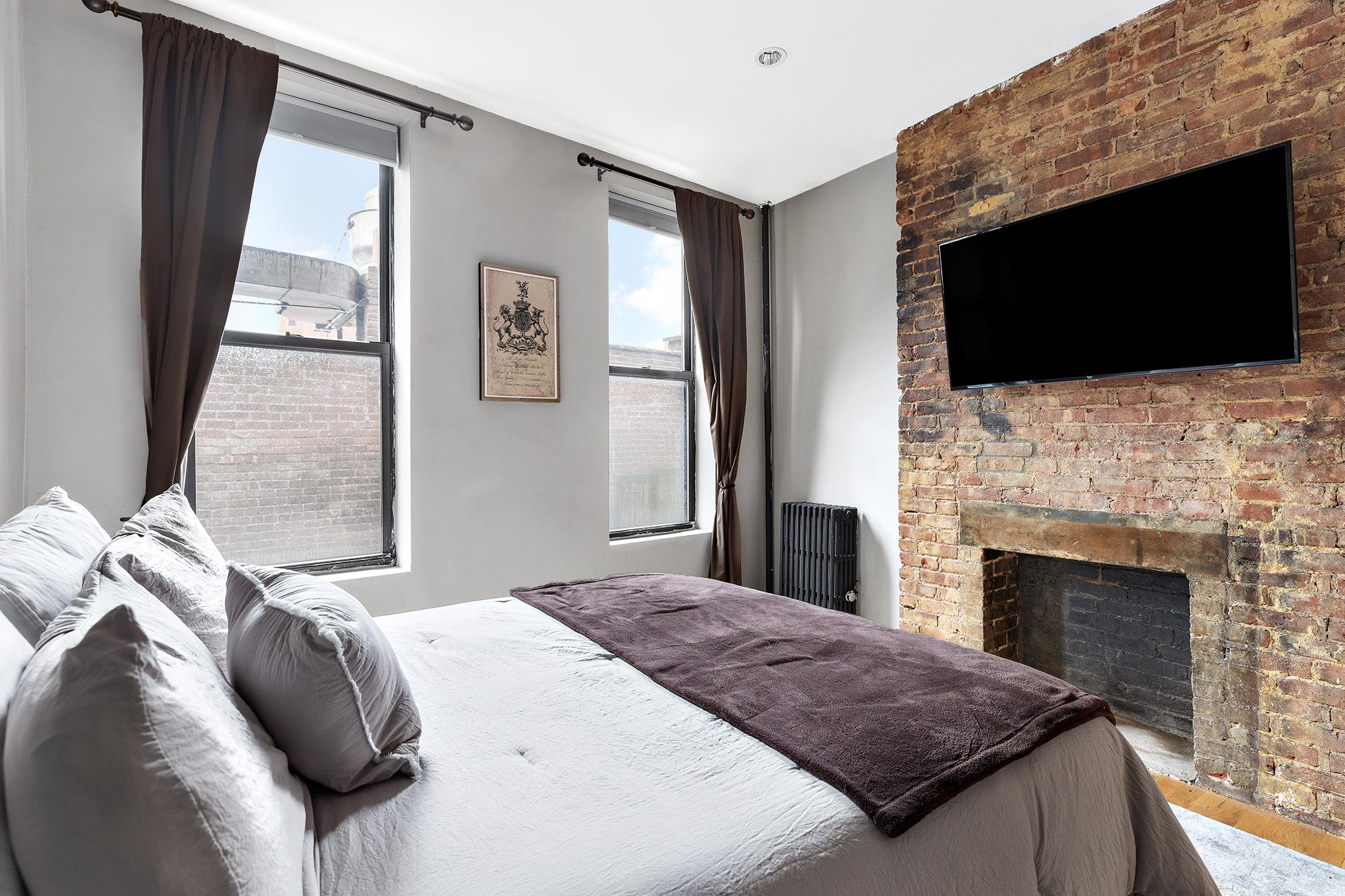167 Grand Street, Unit 2 Brooklyn, NY 11249 - Photo 4 of 7 a bedroom with a bed and a flat screen tv