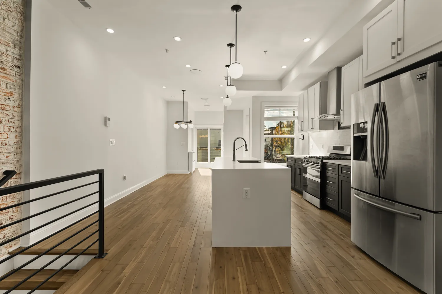 a kitchen with stainless steel appliances granite countertop a refrigerator a stove oven a sink dishwasher and a refrigerator with wooden floor