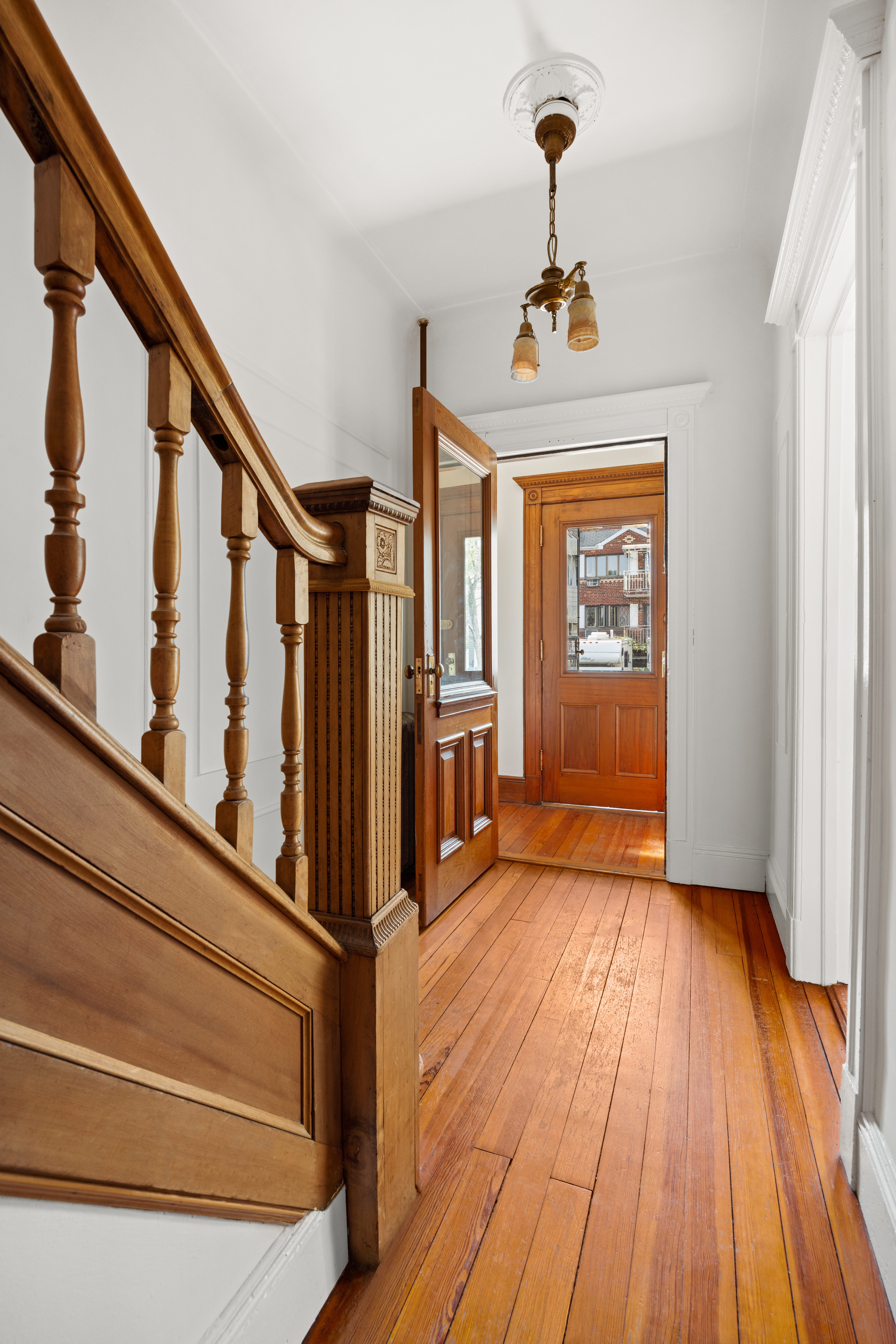 99 East 2nd Street Brooklyn, NY 11218 - Photo 9 of 24 a view of a hallway with wooden floor and staircase