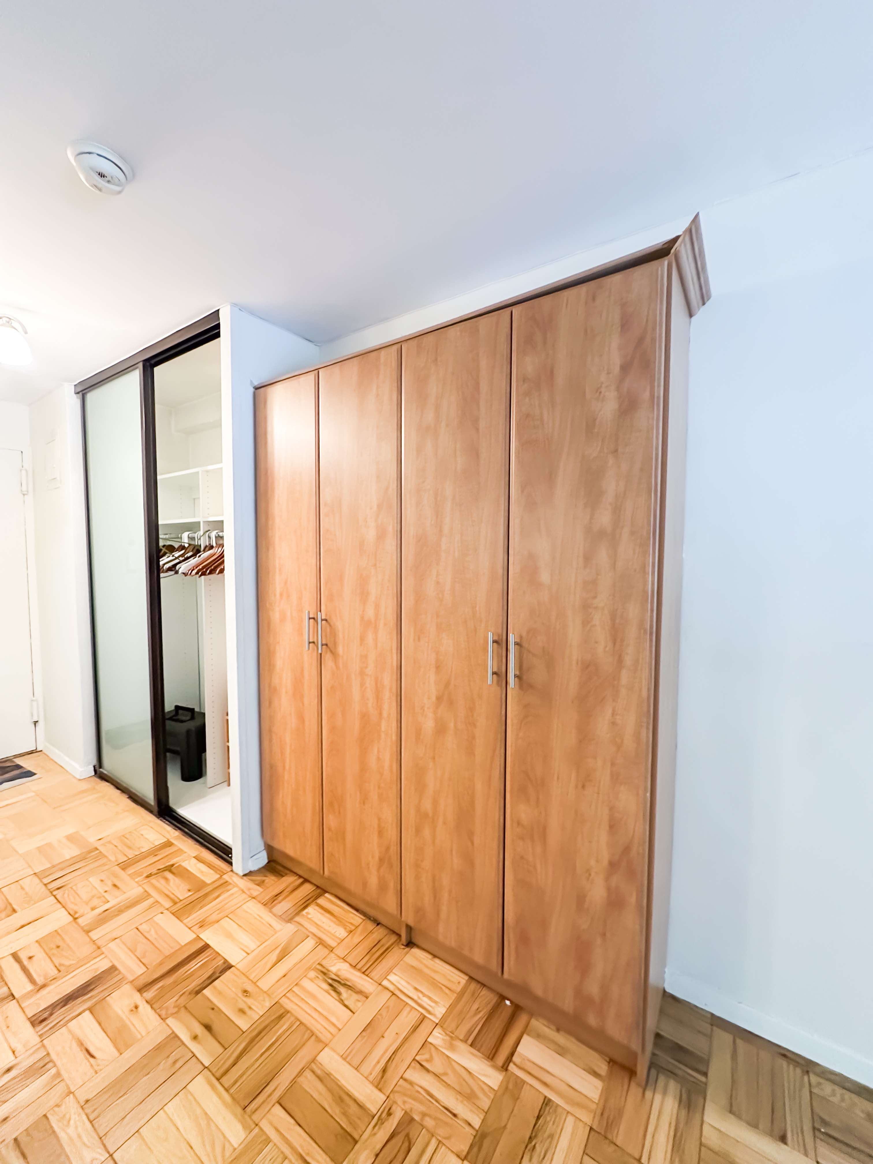 301 East 22nd Street, Unit 2H Manhattan, NY 10010 - Photo 6 of 16 a view of a bedroom with wooden floor and bathroom