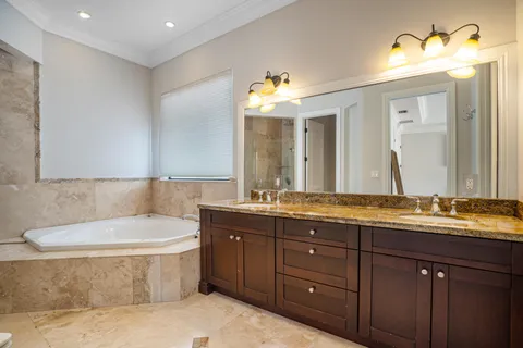 a bathroom with a tub double sink and mirror