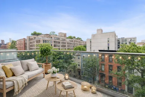 a view of a balcony with couches and wooden floor