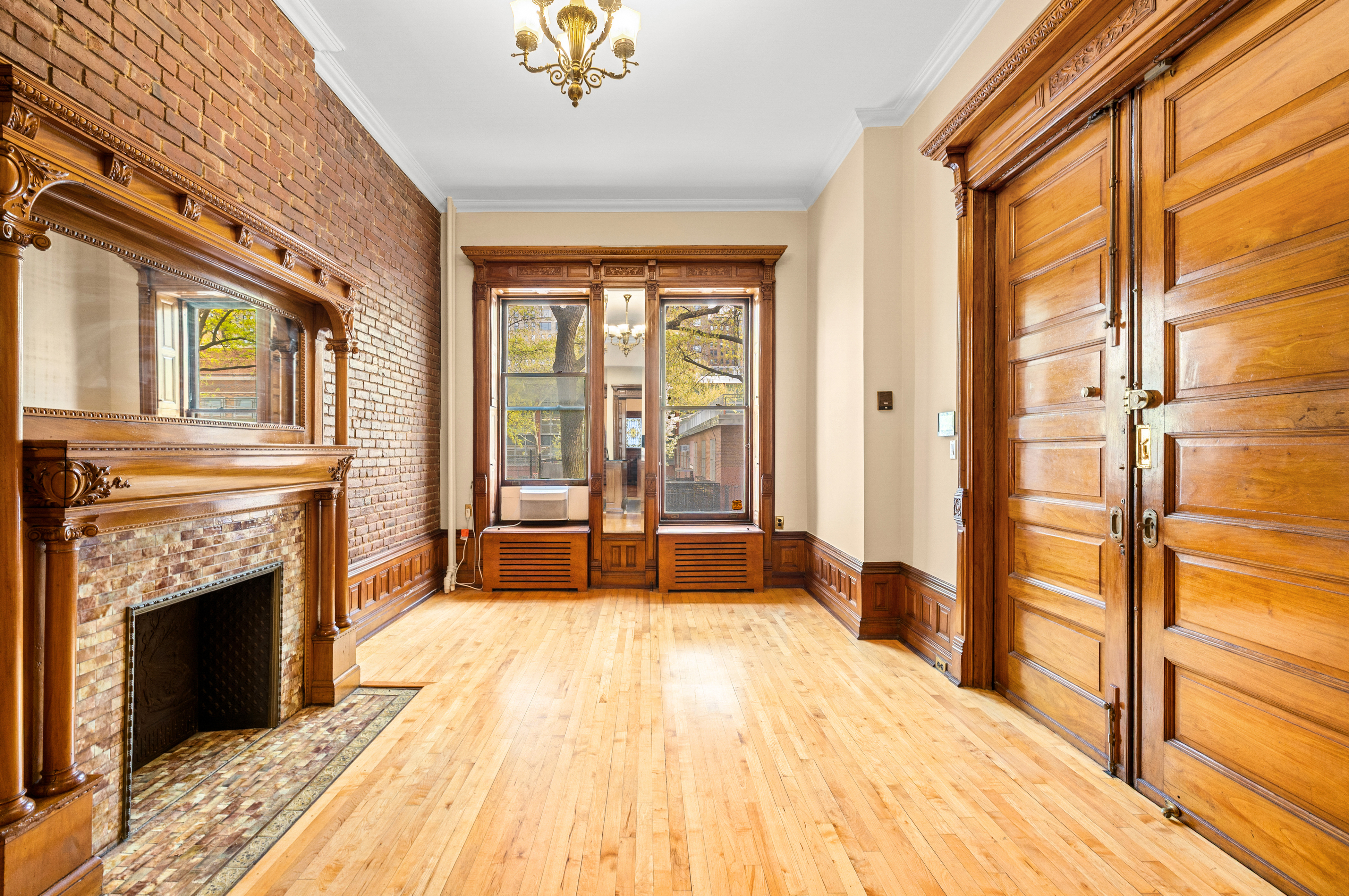 154 West 77th Street, Unit #1 Manhattan, NY 10024 - Photo 1 of 10 a spacious bedroom with a bed and a chandelier