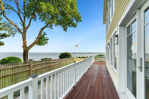 a view of a balcony with wooden floor and fence