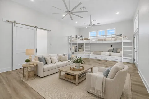 a large kitchen with kitchen island a stove a sink dishwasher a refrigerator and white cabinets with wooden floor