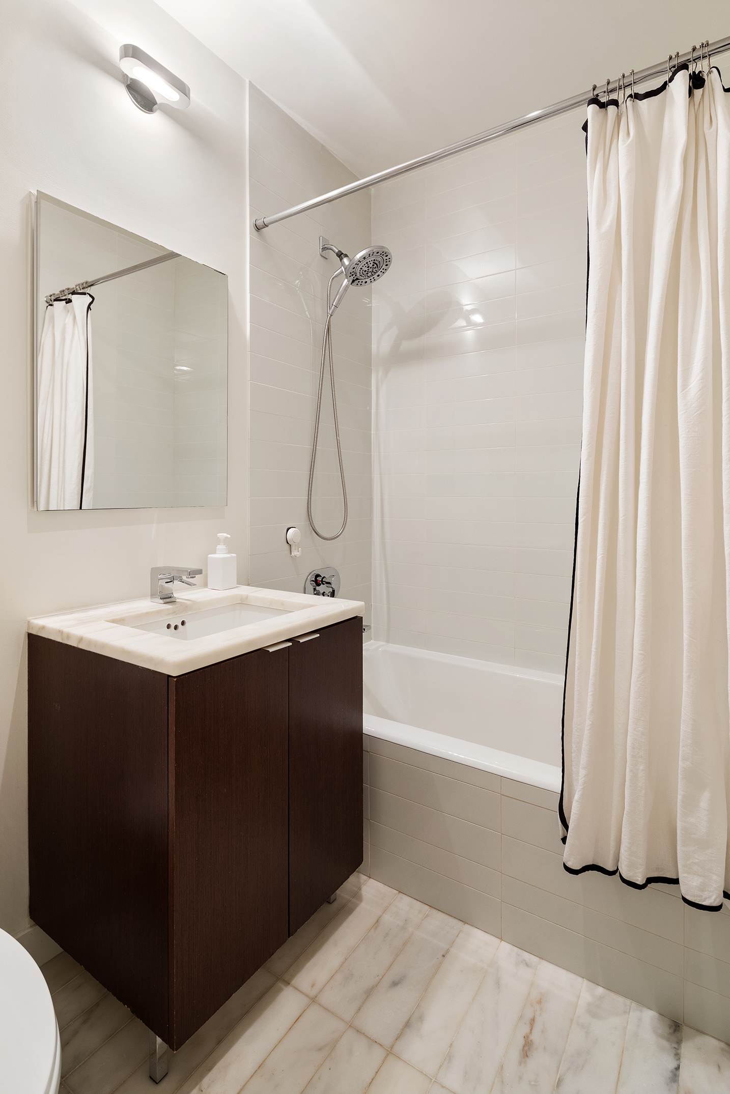 101 Warren Street, Unit 2010 Manhattan, NY 10007 - Photo 17 of 18 a bathroom with a sink vanity granite tub and shower