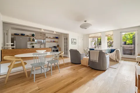a dining room with wooden floor and glass windows