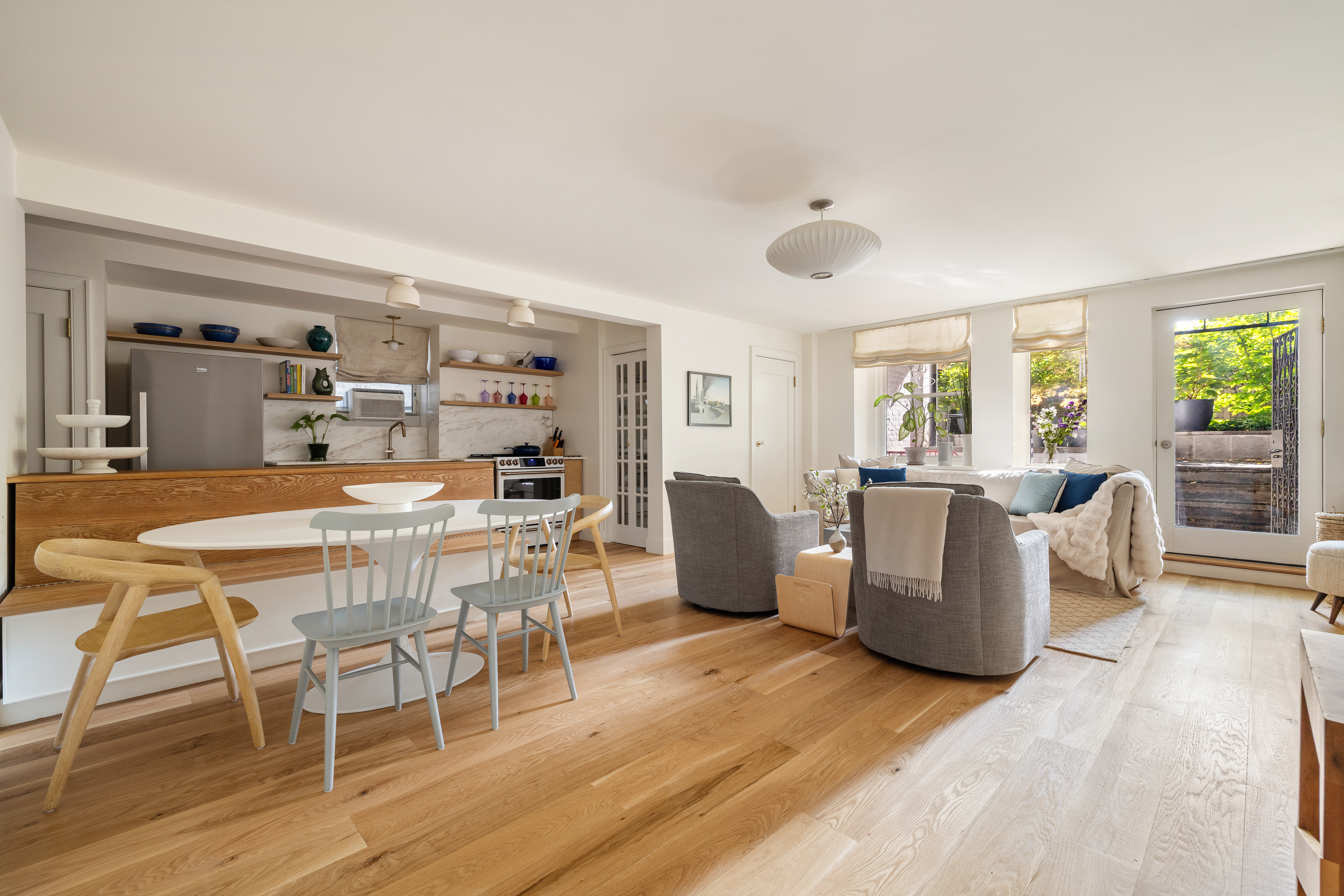 a dining room with wooden floor and glass windows