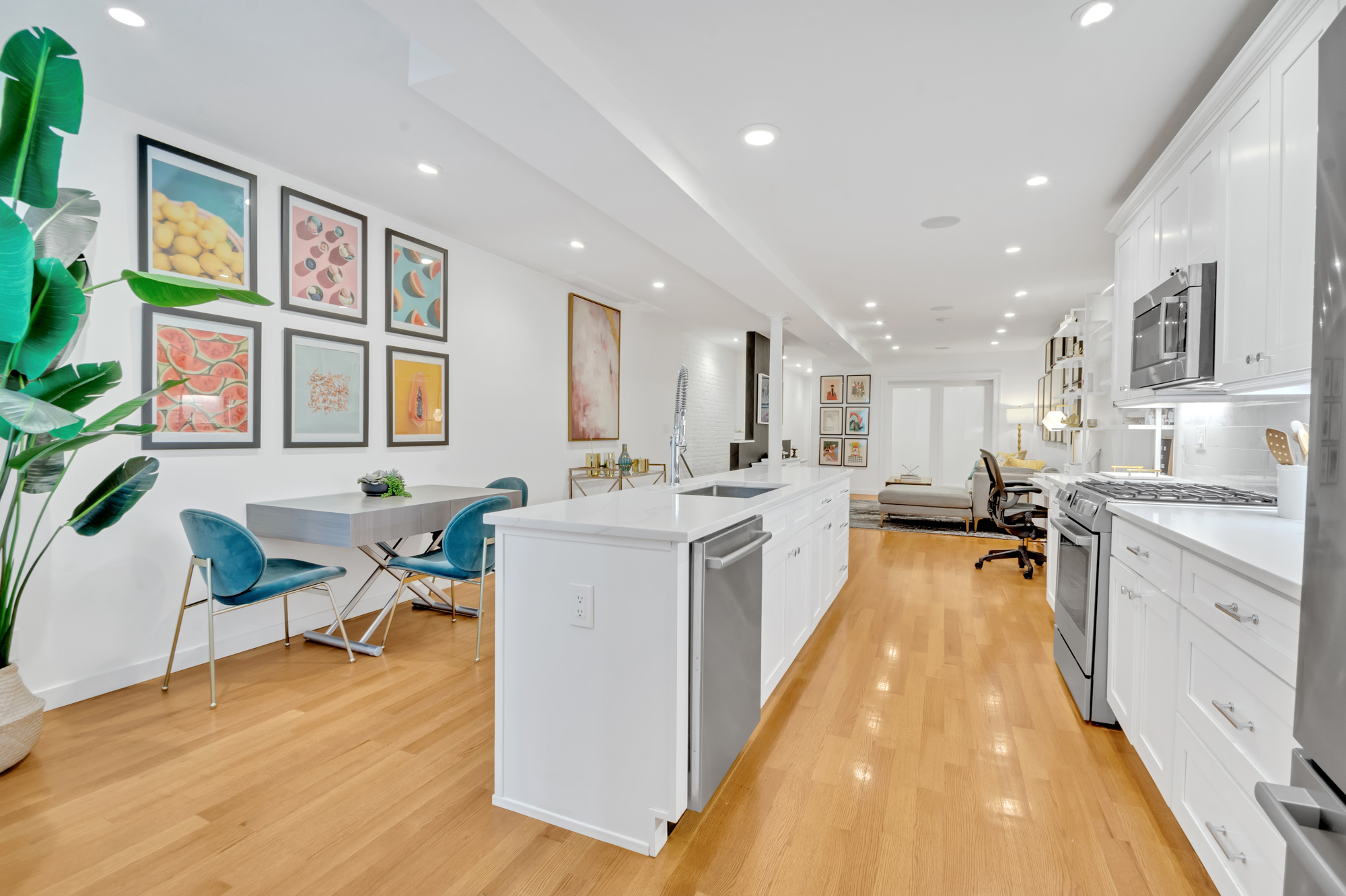 216 West 137th Street, Unit GARDEN Manhattan, NY 10030 - Photo 7 of 13 a large kitchen with stainless steel appliances kitchen island granite countertop a large kitchen island a stove a sink a dining table and chairs with wooden floor