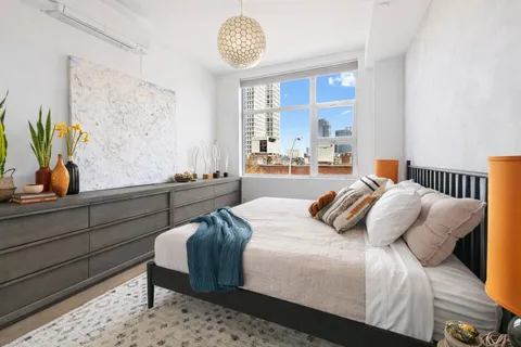 a bedroom with a bed a chandelier and window