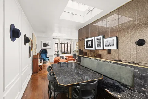 a dining room with stainless steel appliances kitchen island granite countertop a table chairs in it and a wooden floor