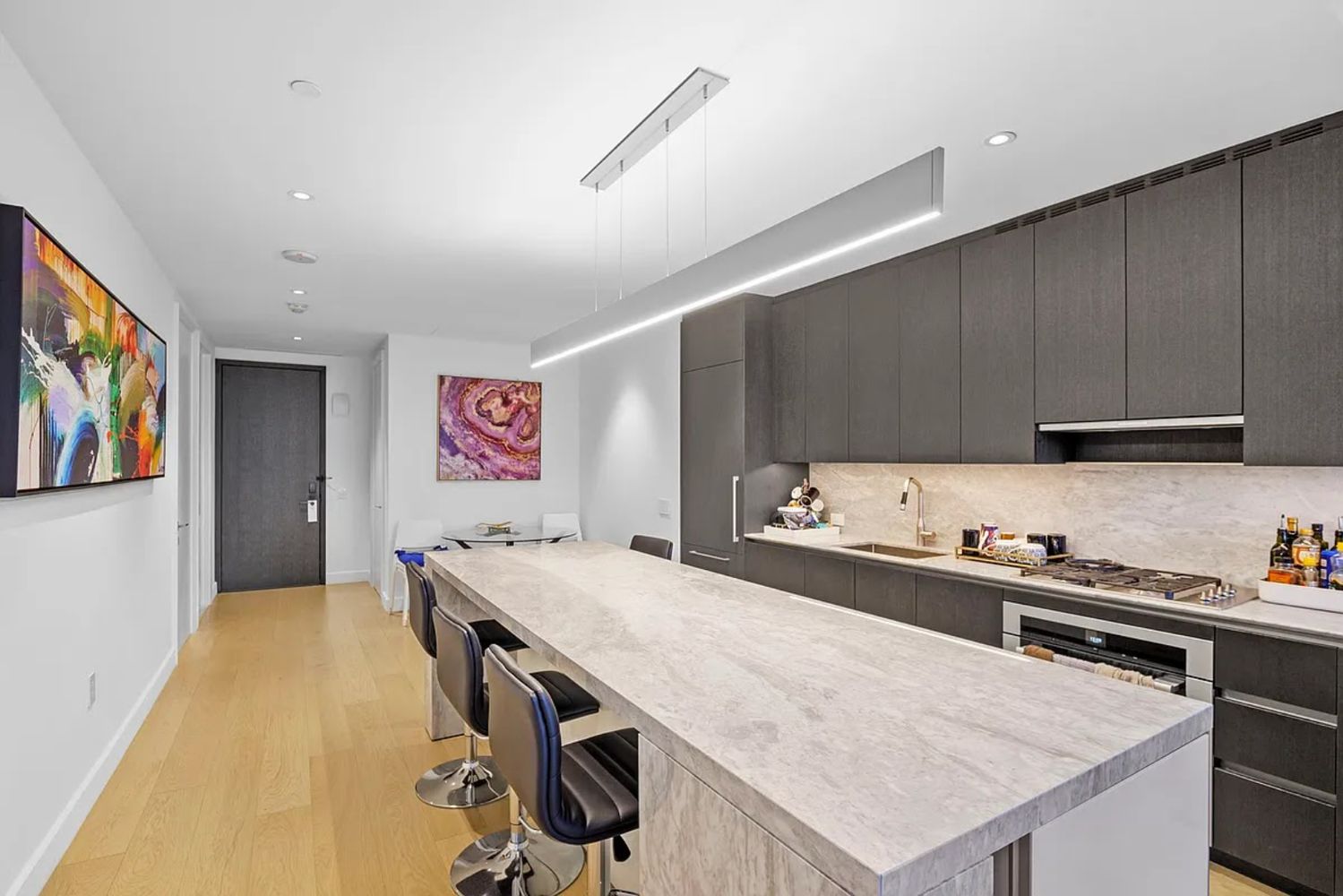 15 Hudson Yards, Unit 28J Manhattan, NY 10001 - Photo 2 of 5 a kitchen with stainless steel appliances cabinets and wooden floor