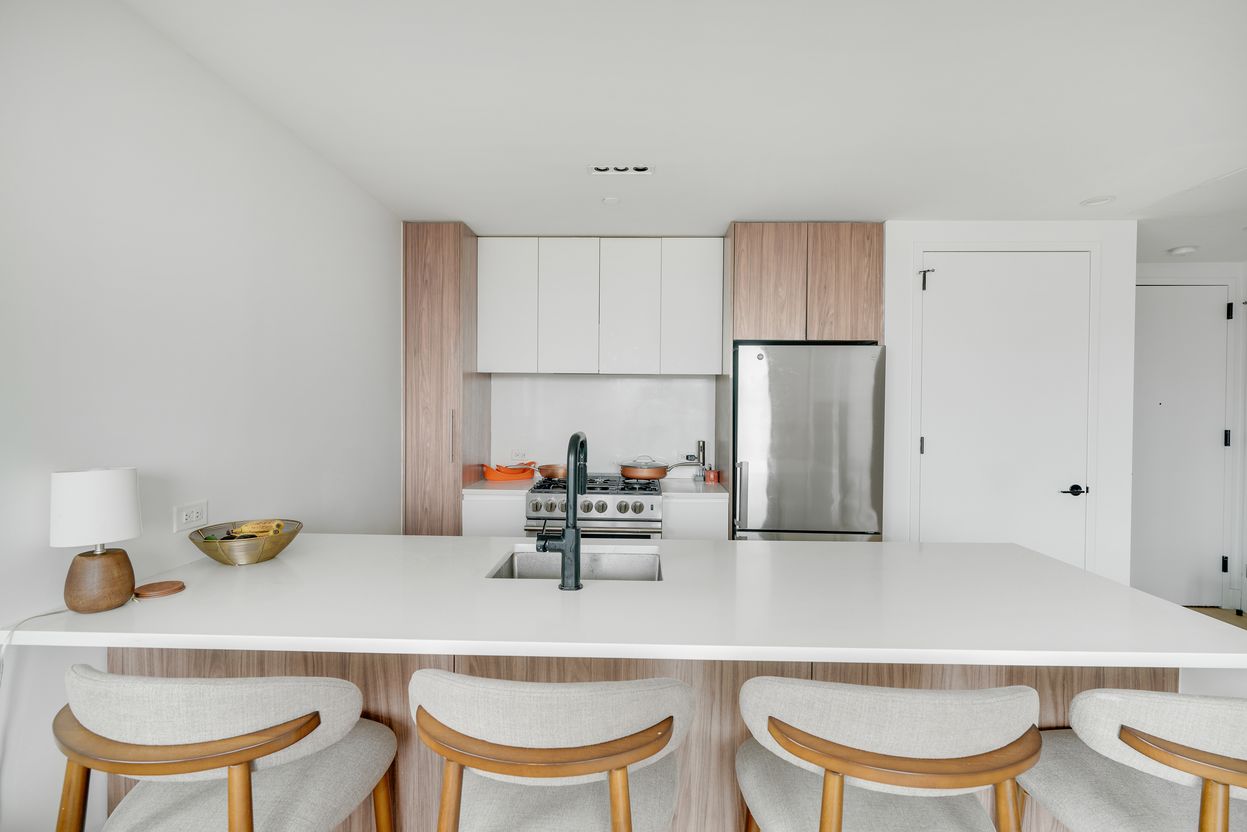 224 West 124th Street, Unit 1501 Manhattan, NY 10027 - Photo 4 of 23 a kitchen with a dining table chairs and a refrigerator