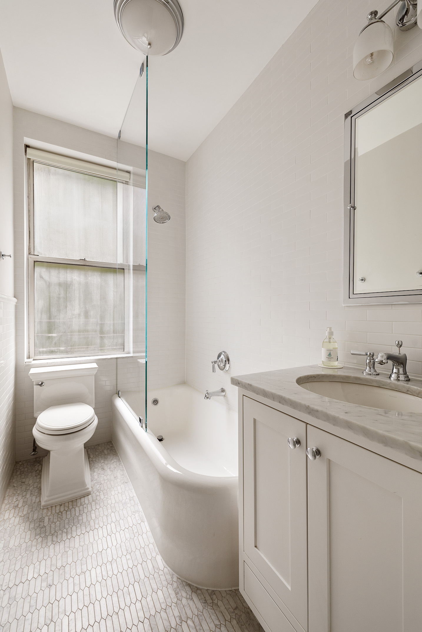 201 West 89th Street, Unit 2F Manhattan, NY 10024 - Photo 7 of 20 a bathroom with a granite countertop sink toilet a large mirror and a bathtub