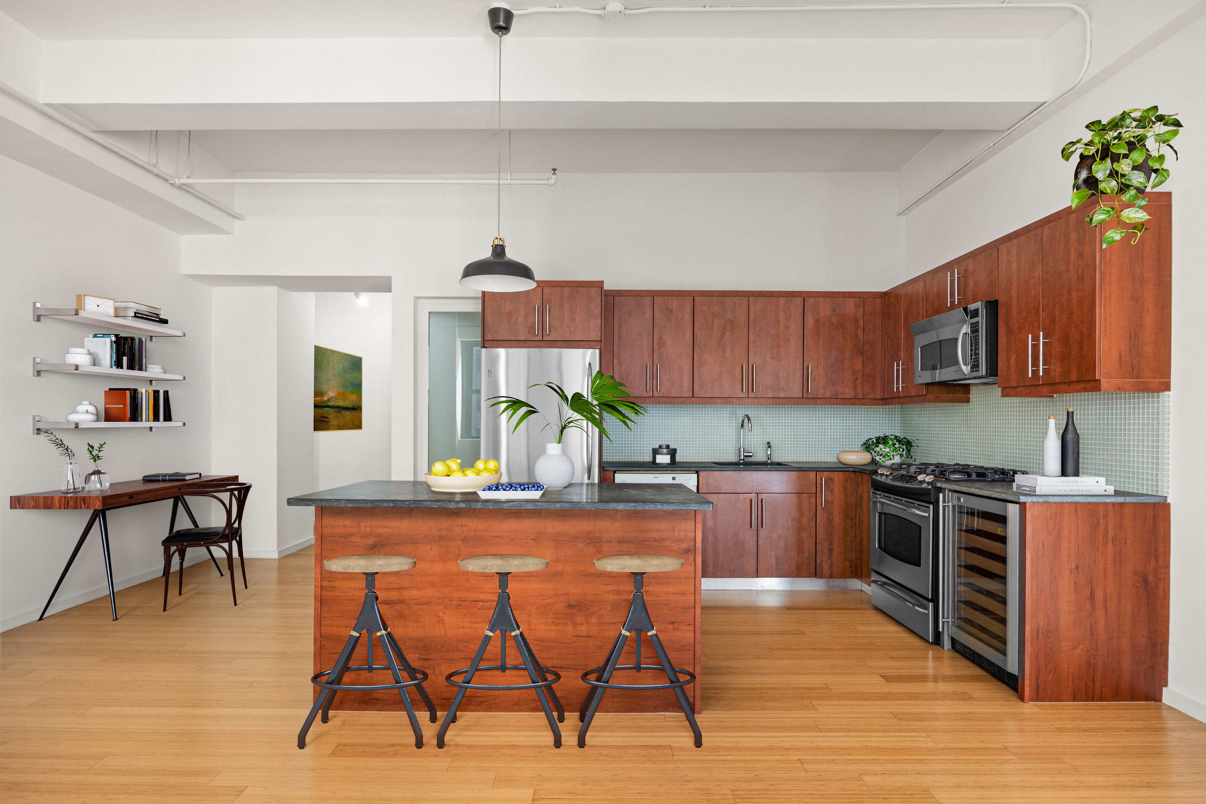 365 Bridge Street, Unit 5N Brooklyn, NY 11201 - Photo 2 of 12 a kitchen with stainless steel appliances kitchen island granite countertop a table chairs in it and wooden floors