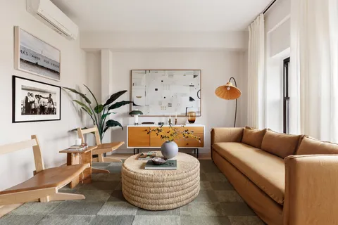 a living room with furniture kitchen view and a window