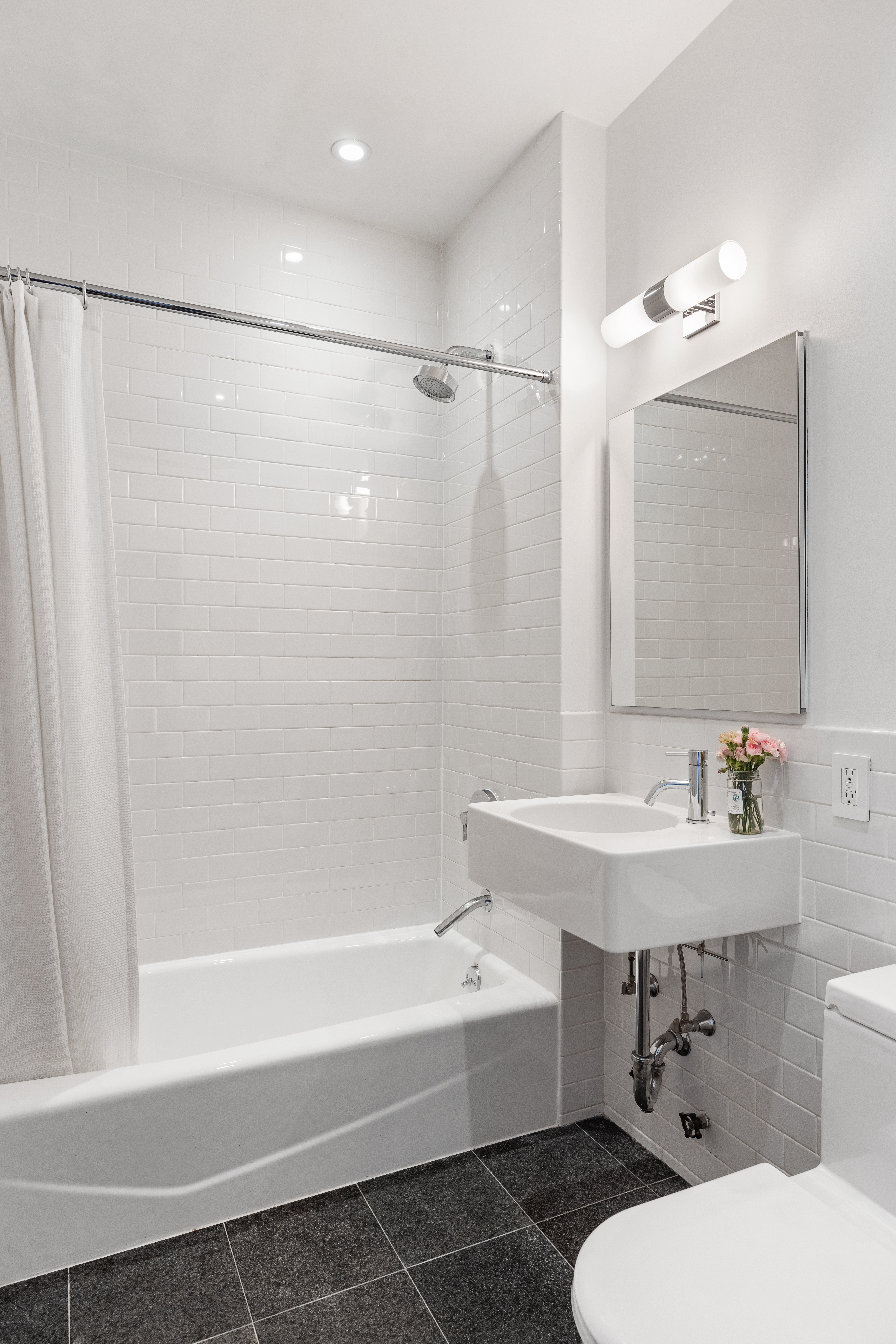 175 East Broadway, Unit 6D Manhattan, NY 10002 - Photo 14 of 18 a bathroom with a sink toilet and shower