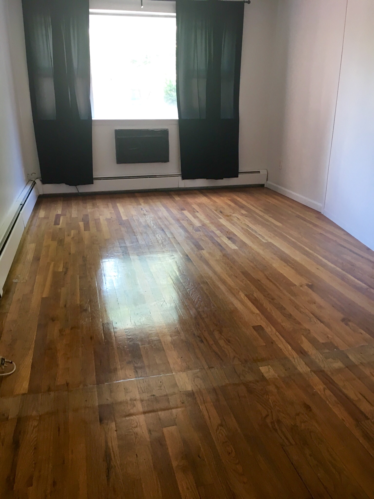 23-12 24th Avenue, Unit 1 Queens, NY 11102 - Photo 7 of 10 a view of an empty room and window