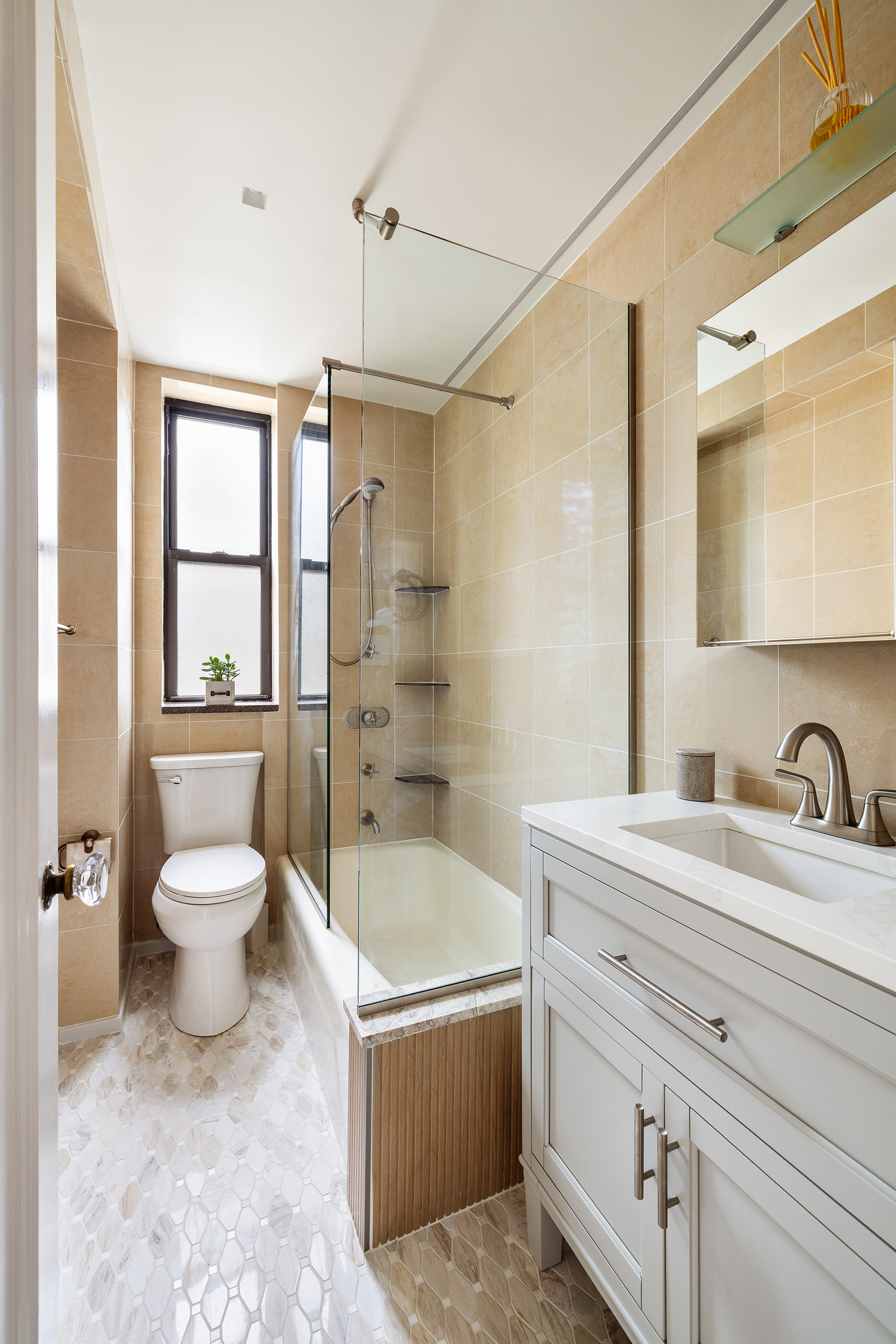 119 East 84th Street, Unit 9C Manhattan, NY 10028 - Photo 6 of 10 a bathroom with a granite countertop toilet a sink and a bathtub