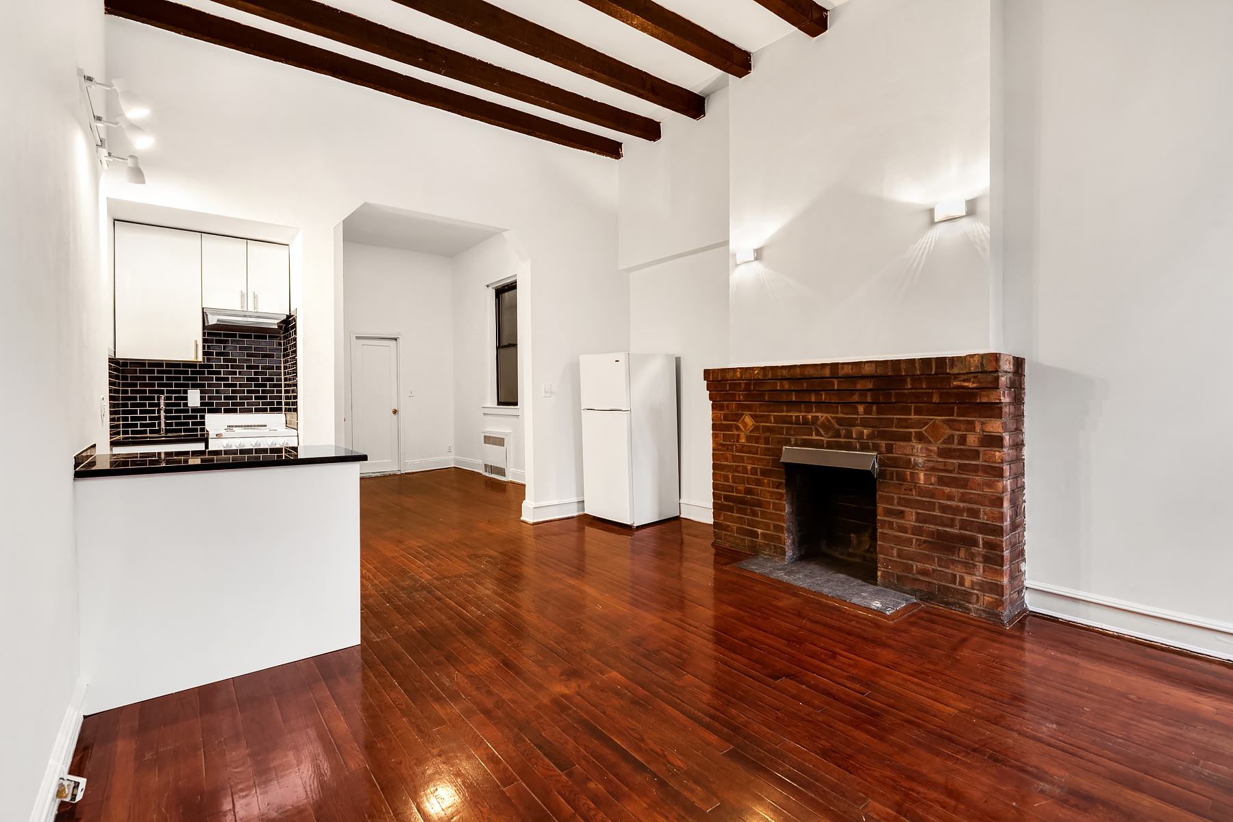 47 Jane Street Manhattan, NY 10014 - Photo 7 of 9 a view of an empty room with wooden floor and a fireplace