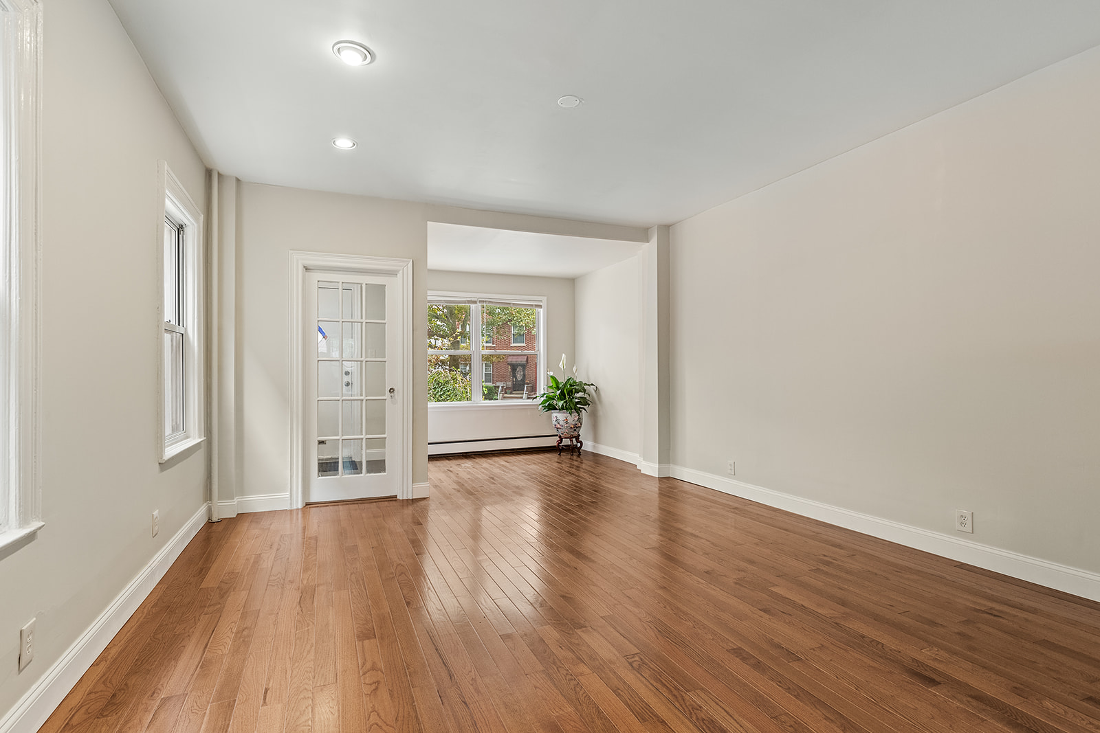 181 Terrace Place Brooklyn, NY 11218 - Photo 5 of 22 a view of an empty room with wooden floor and a window