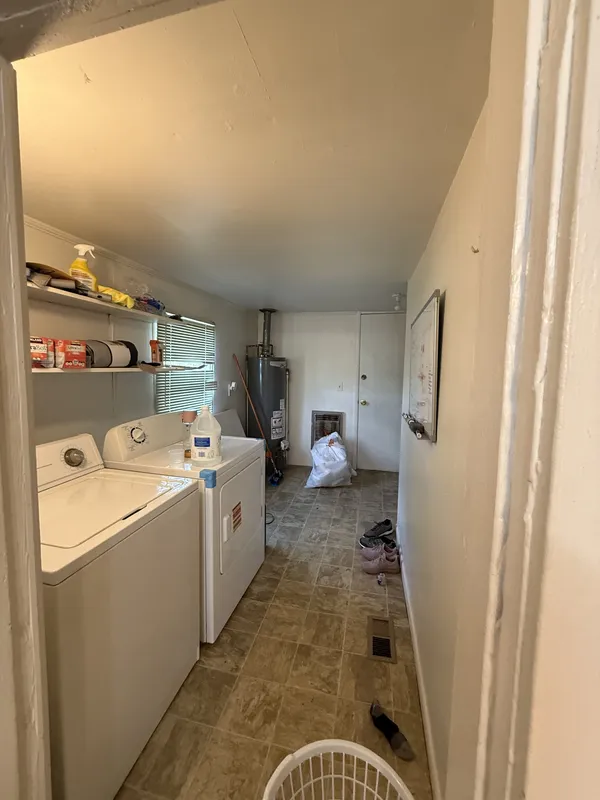 a storage room with a washer dryer and next to a window