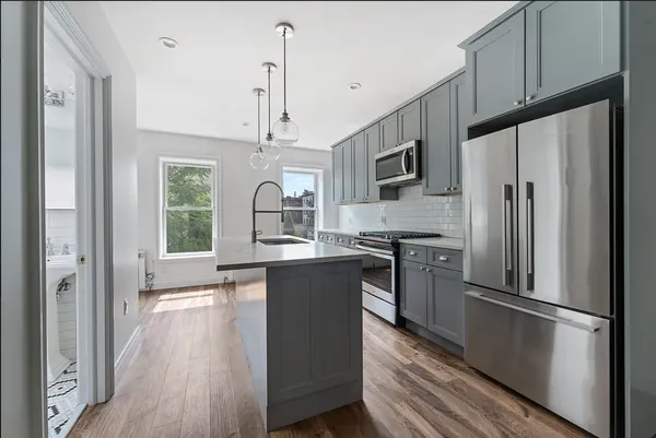 a kitchen with stainless steel appliances a refrigerator sink and microwave