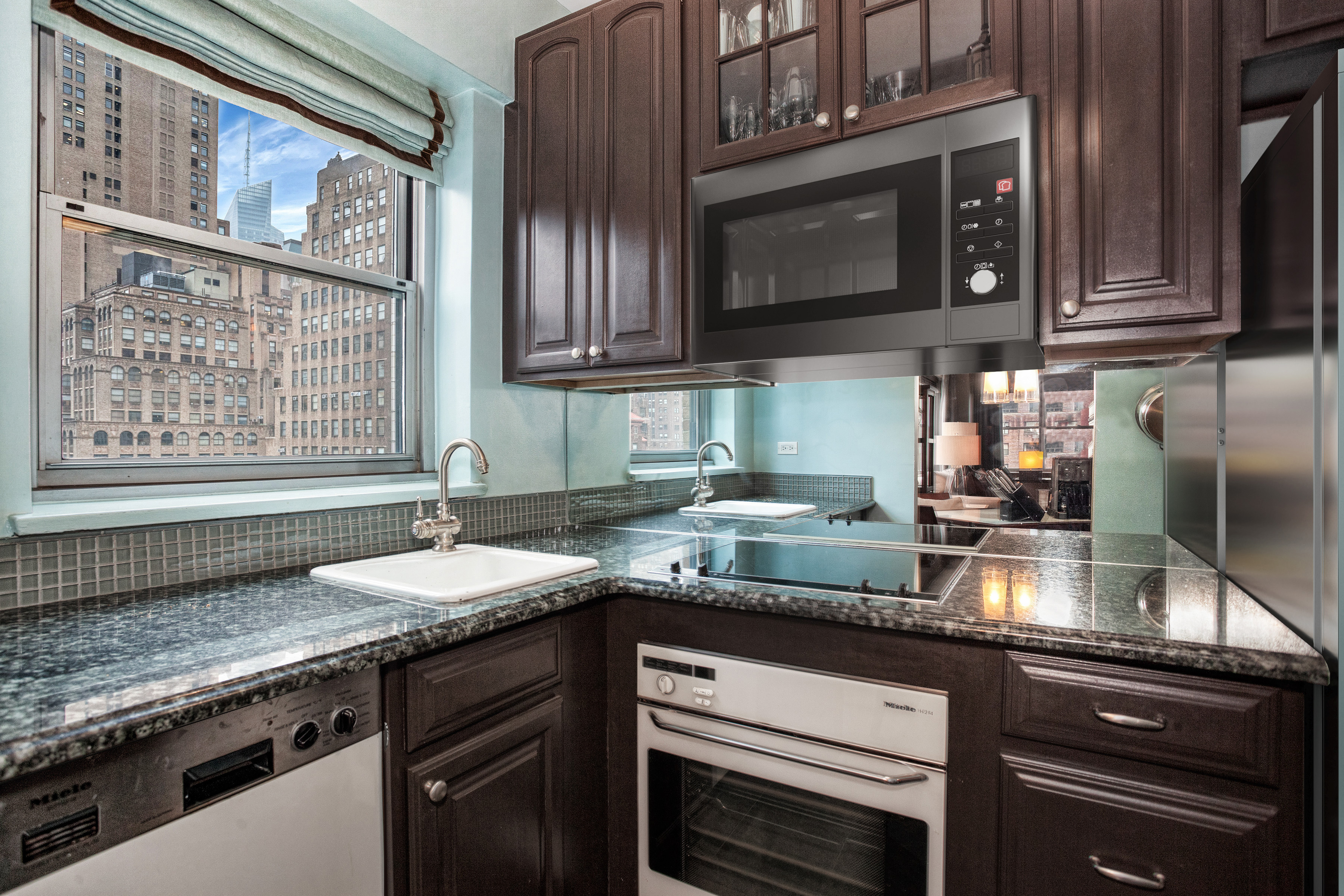80 Park Avenue, Unit 17B Manhattan, NY 10016 - Photo 4 of 10 a kitchen with granite countertop stainless steel appliances a stove sink and cabinets